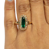 22K Yellow Gold Elongated Vibrant Green Gem with a Diamond Halo on the hand from the top 