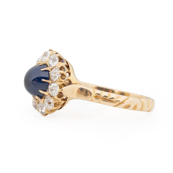 Victorian 14K Yellow Gold Deep Blue Cambodian Cabochon Sapphire and Old European Cut Diamond Halo Cocktail Ring form the right showing the organic carving of the shanks 