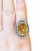 Edwardian 14K Yellow Gold and Platinum Citrine Carved Cameo with Diamond and Sapphire Halo Scalloped Edge Cocktail Ring on the hand from the top show casing the size 